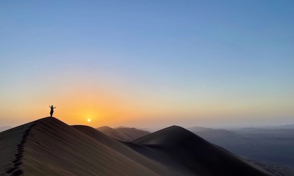 una ragazza al tramonto su una duna nel deserto di Lut nel Khorasan la regione in cui si passa col viaggio dello zafferano