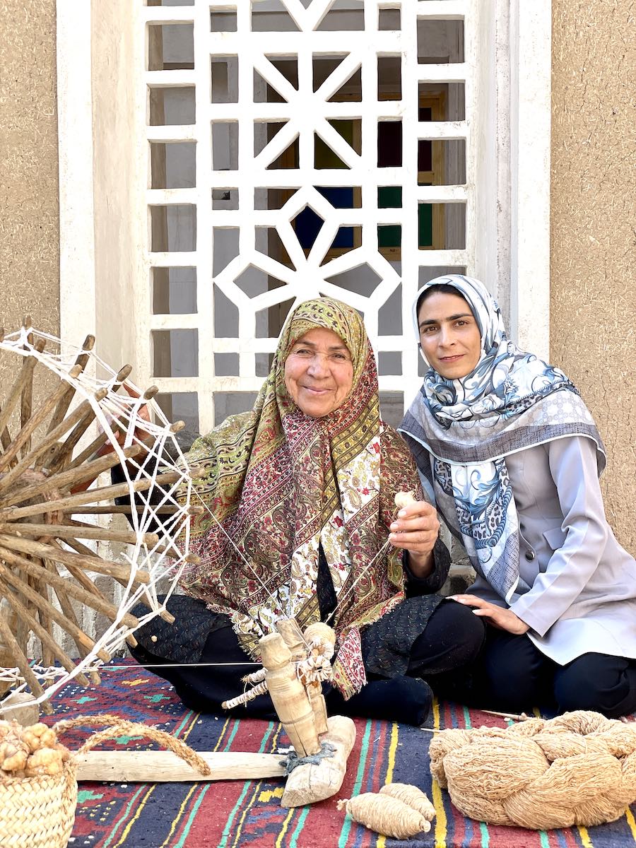 Maryam e la sua maestra di tessitura del cotone marrone con cui sono realizzate le sciarpe equo solidale 